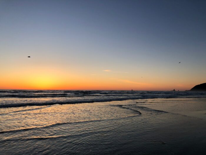 Solnedgång vid stranden i Cannon Beach