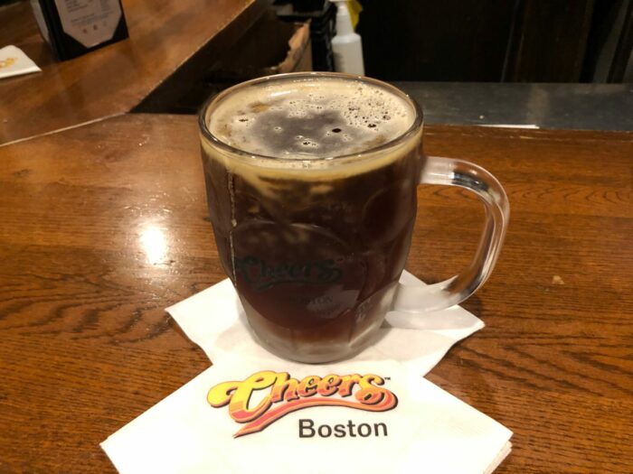 Ölglas på bardisk fylld med mörkröd öl
