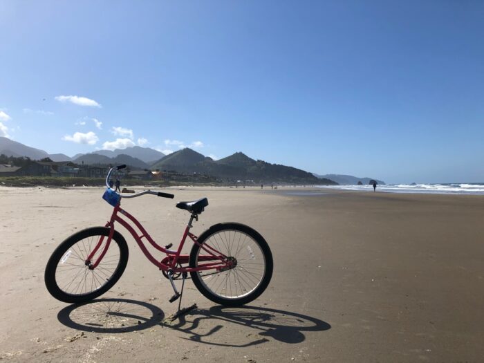 Cykel på strand med kullar i bakgrunden